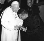 
Photo courtsey of Servizio Fotografico de �L�O.R.�: The Rev. Anthony Figueiredo kisses the pope�s cross as part of his six years of service to the pope. 